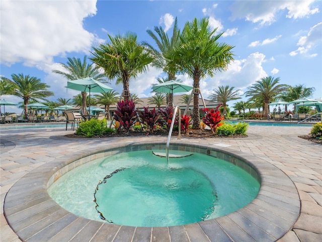 view of swimming pool with a patio and a hot tub