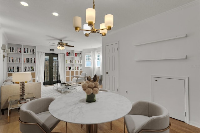 dining room featuring french doors, ornamental molding, light hardwood / wood-style floors, and built in shelves