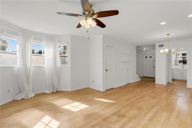 interior space featuring ceiling fan with notable chandelier and light wood-type flooring