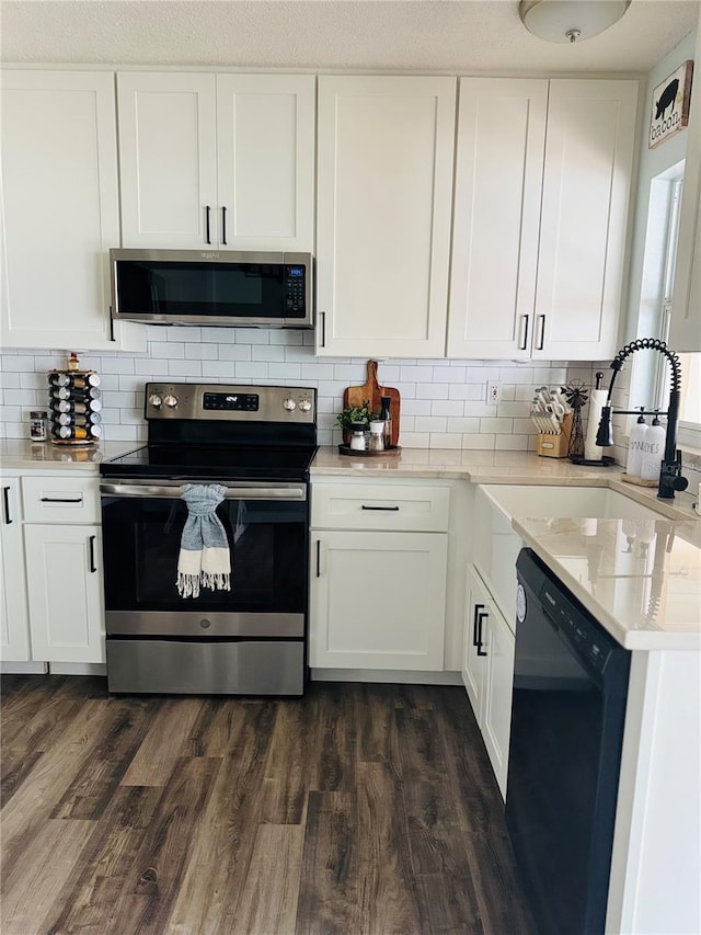 kitchen with white cabinets, appliances with stainless steel finishes, tasteful backsplash, and sink