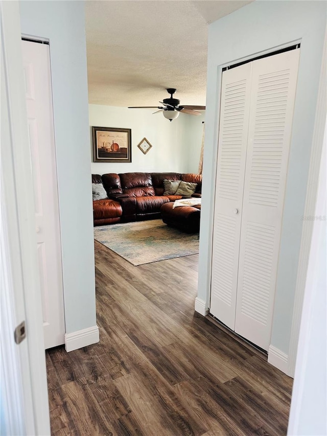 hall featuring a textured ceiling and dark hardwood / wood-style floors