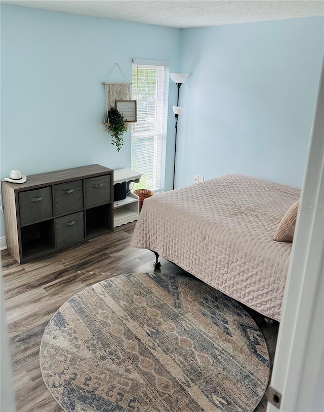 bedroom with a textured ceiling and dark wood-type flooring