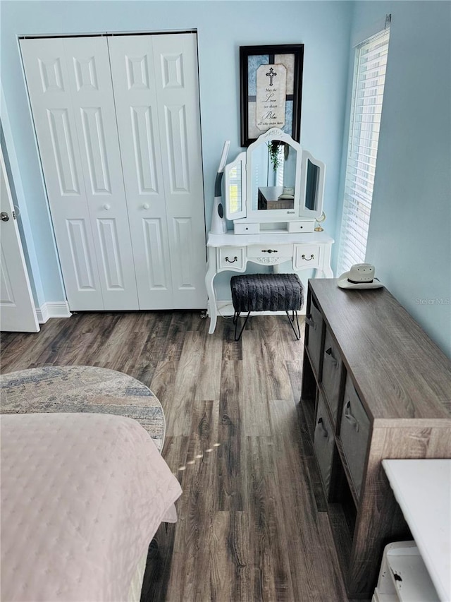 bedroom with a closet and dark wood-type flooring