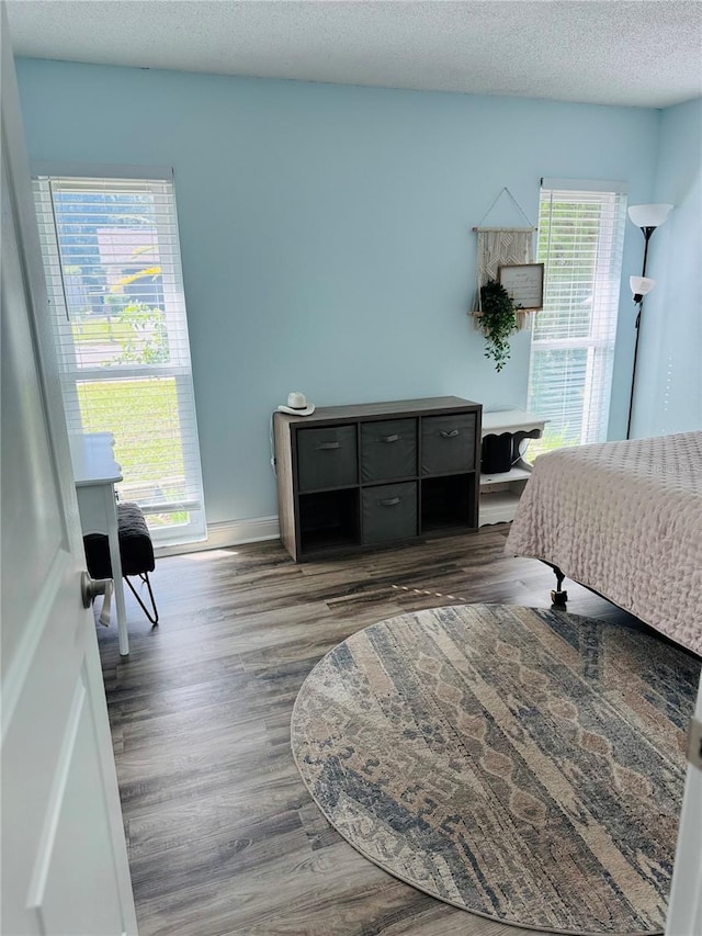 bedroom featuring dark hardwood / wood-style flooring and a textured ceiling