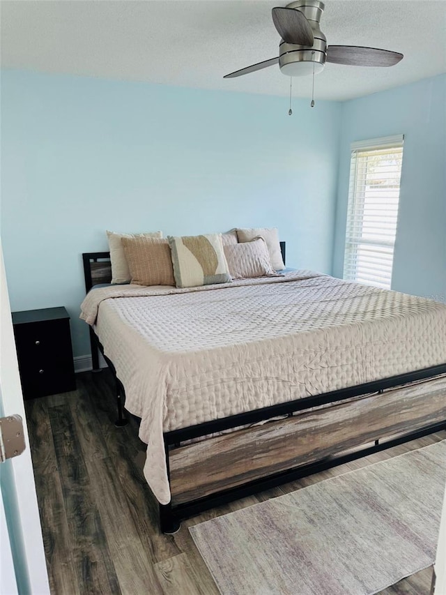 bedroom with dark hardwood / wood-style floors and ceiling fan