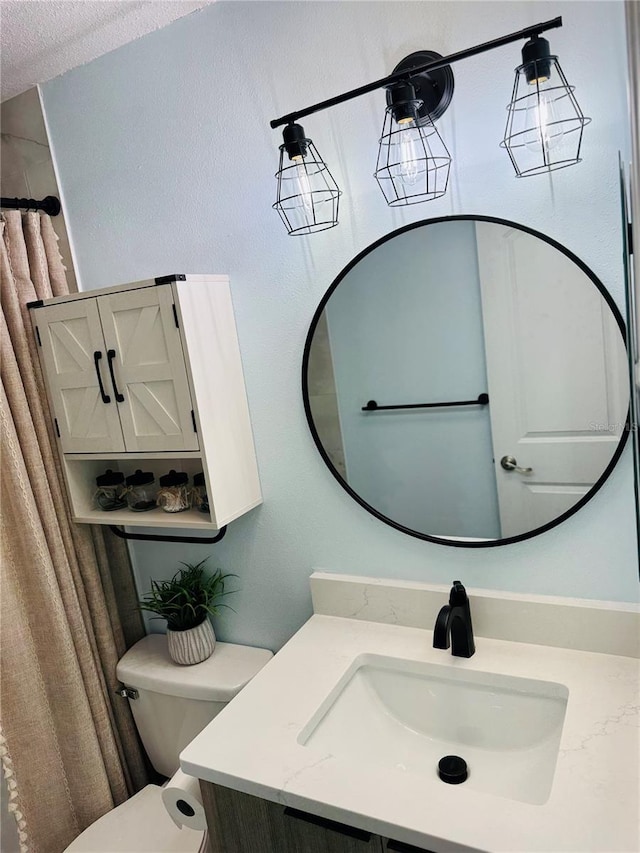 bathroom with vanity, a shower with shower curtain, a textured ceiling, and toilet