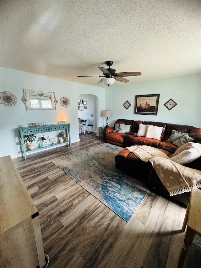 living room with wood-type flooring, a textured ceiling, and ceiling fan