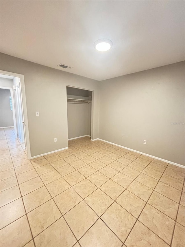 unfurnished bedroom with light tile patterned floors and a closet