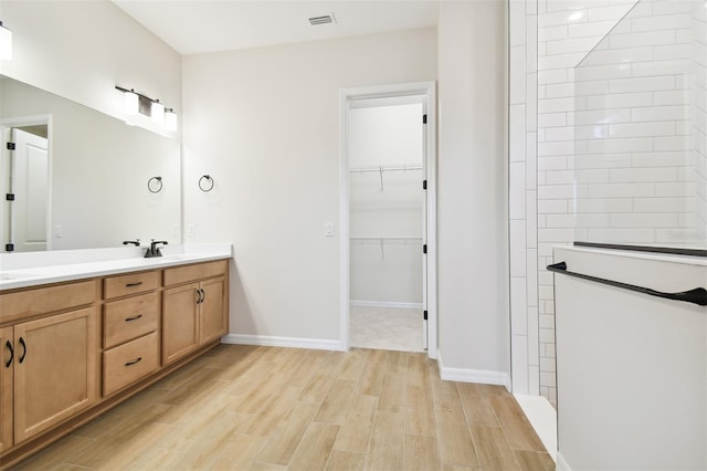 bathroom with a shower, vanity, and wood-type flooring