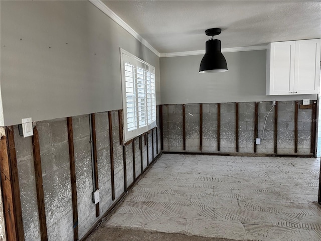 empty room featuring a textured ceiling and ornamental molding