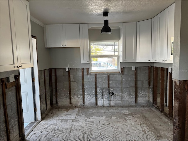 kitchen with white cabinets and a textured ceiling