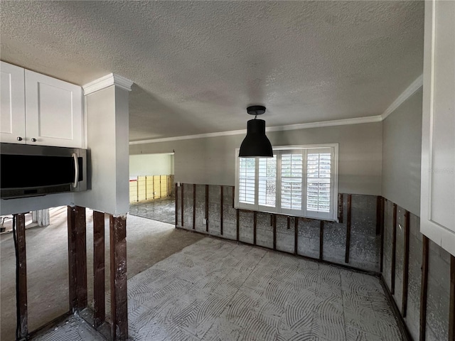 empty room with crown molding and a textured ceiling