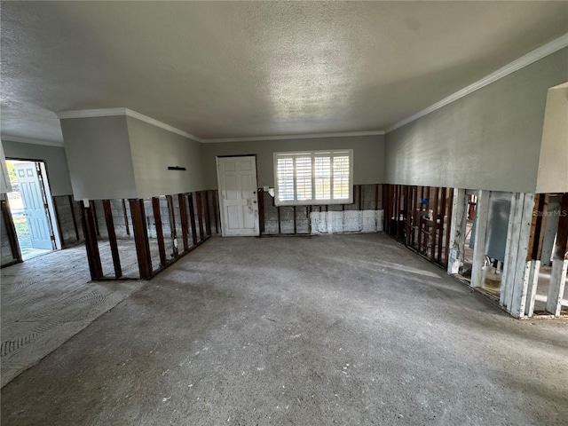 empty room featuring a textured ceiling and crown molding