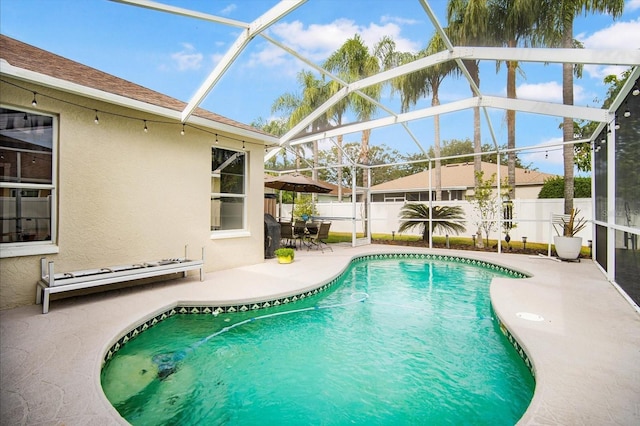 view of swimming pool featuring a patio area and glass enclosure