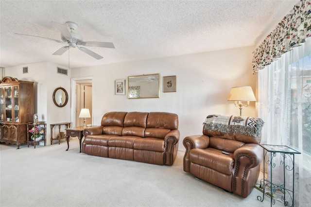 living room with ceiling fan, carpet floors, and a textured ceiling