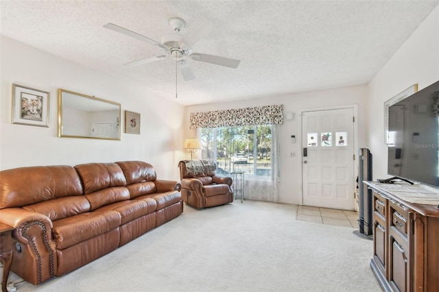 living room featuring ceiling fan, light colored carpet, and a textured ceiling