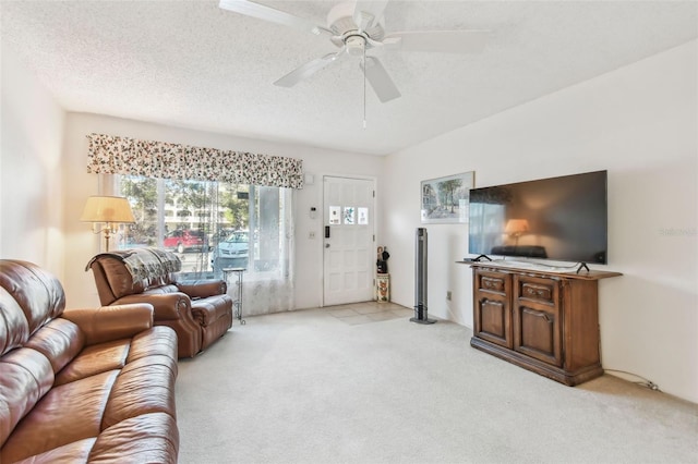 living room featuring a textured ceiling, light colored carpet, and ceiling fan