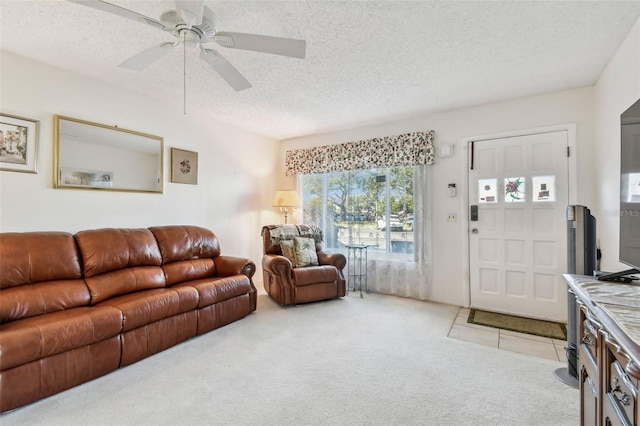 living room featuring ceiling fan, light colored carpet, and a textured ceiling