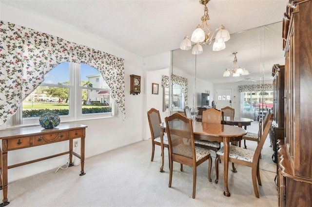 dining room featuring a notable chandelier and light carpet