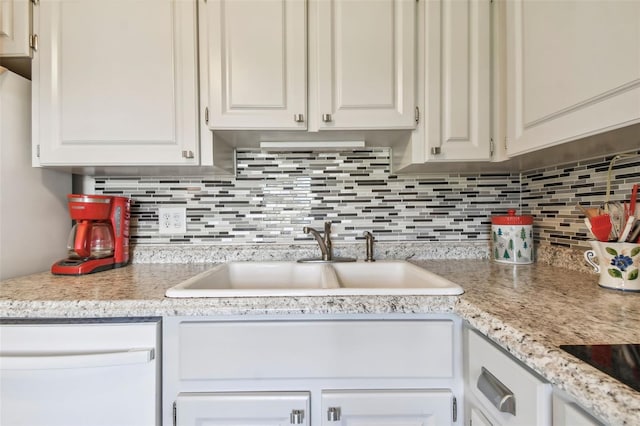 kitchen with white cabinets, decorative backsplash, and sink