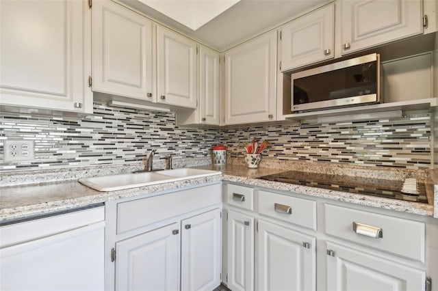 kitchen featuring backsplash, white cabinetry, and sink