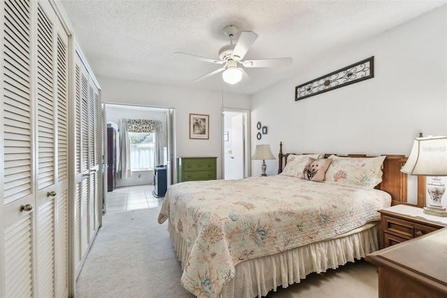 bedroom featuring a textured ceiling, ceiling fan, and light carpet