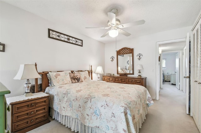 bedroom with ceiling fan, light carpet, and a closet