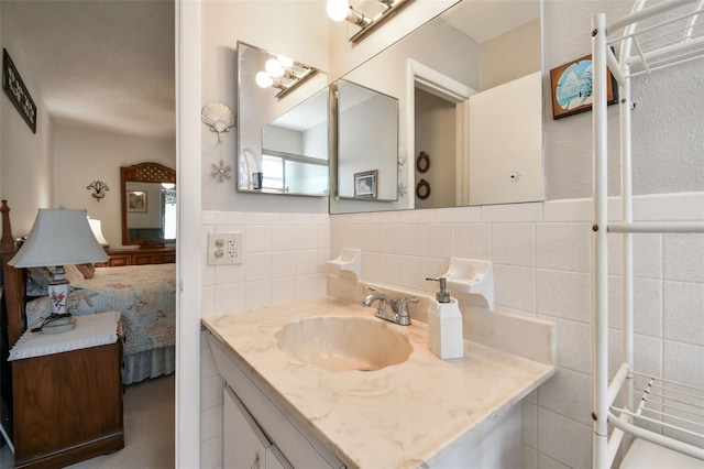 bathroom featuring vanity and tile walls