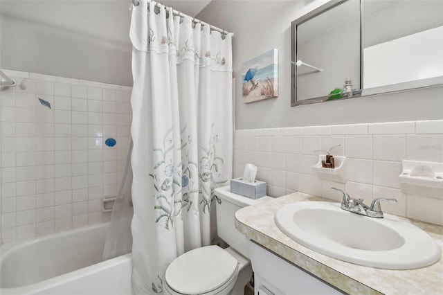 full bathroom with shower / tub combo with curtain, vanity, tile walls, and toilet