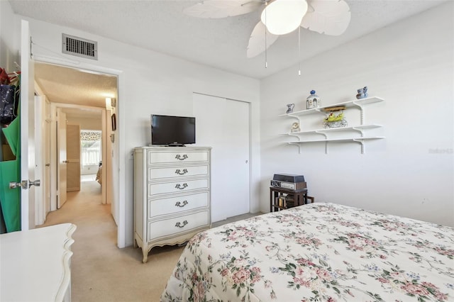 carpeted bedroom with a textured ceiling and ceiling fan