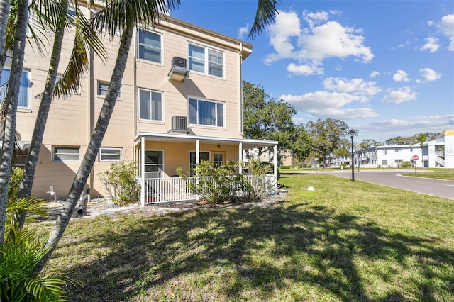 view of front of property with covered porch, central AC, and a front lawn