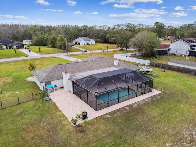 view of pool featuring glass enclosure, a yard, and a patio