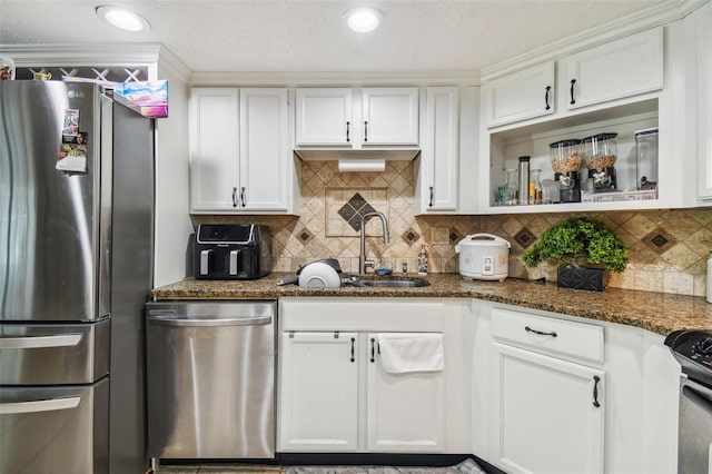 kitchen featuring dark stone countertops, decorative backsplash, sink, stainless steel appliances, and white cabinets