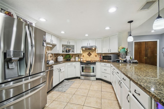 kitchen featuring stainless steel appliances, white cabinetry, and hanging light fixtures