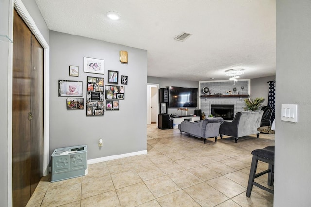 tiled living room with a textured ceiling and a fireplace