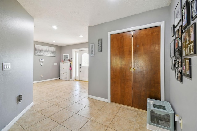 tiled entrance foyer featuring a textured ceiling and heating unit