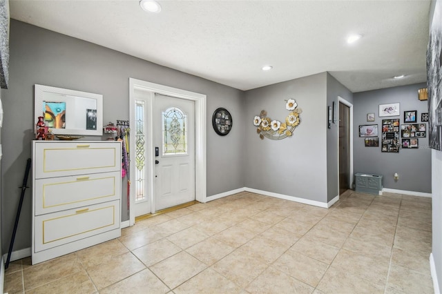 foyer entrance featuring light tile patterned floors and a textured ceiling