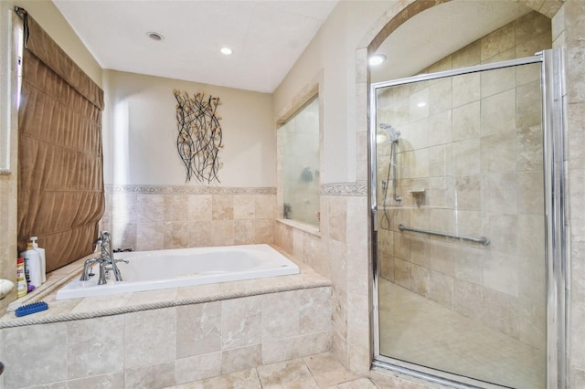 bathroom with tile walls and shower with separate bathtub