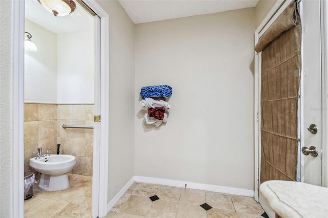 bathroom featuring a bidet, tile patterned flooring, and tile walls