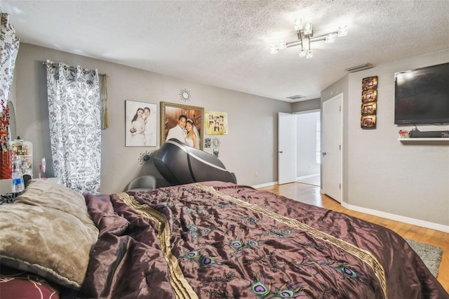 bedroom with a textured ceiling and light hardwood / wood-style flooring