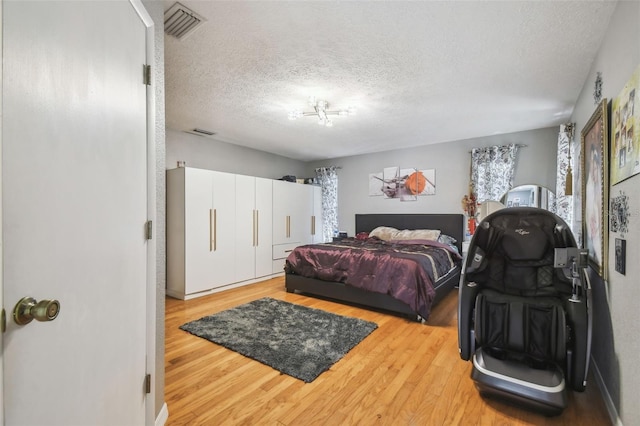 bedroom featuring a textured ceiling and light hardwood / wood-style flooring