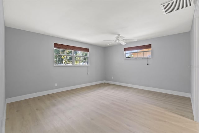 empty room with ceiling fan and light hardwood / wood-style flooring