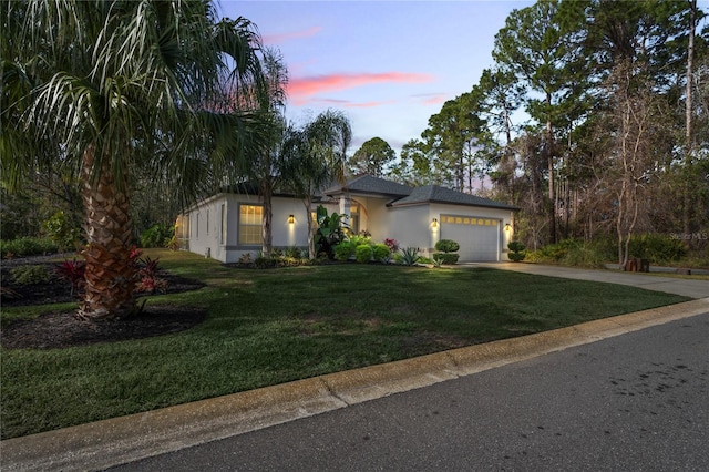 view of front of property featuring a garage and a lawn