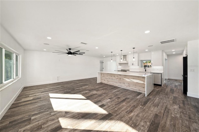 kitchen with refrigerator, custom exhaust hood, a kitchen island, pendant lighting, and white cabinetry