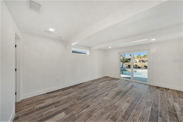 unfurnished room with beam ceiling