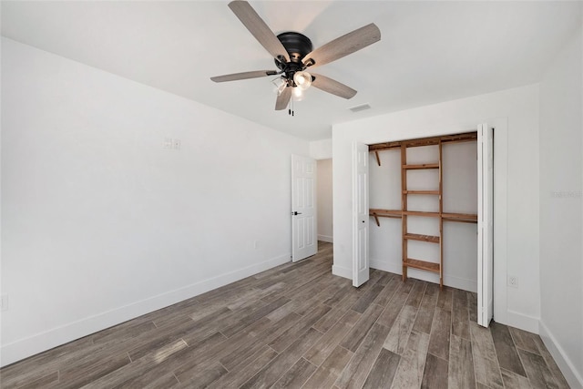 unfurnished bedroom featuring hardwood / wood-style floors, a closet, and ceiling fan