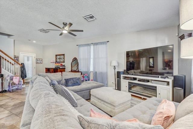 living room featuring a textured ceiling and ceiling fan