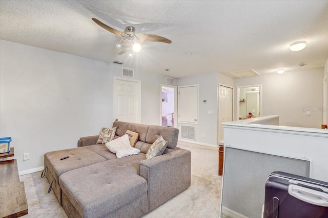 carpeted living room with ceiling fan and a textured ceiling