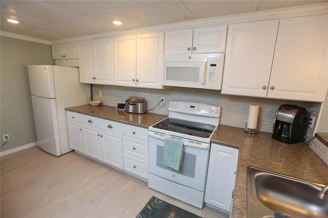 kitchen with decorative backsplash, ornamental molding, white appliances, sink, and white cabinetry