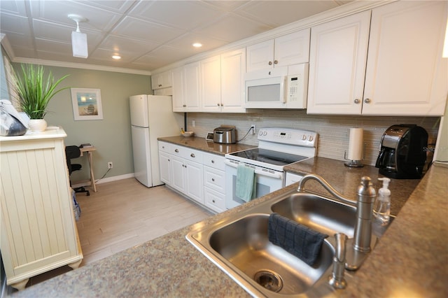 kitchen featuring decorative backsplash, white cabinetry, and white appliances